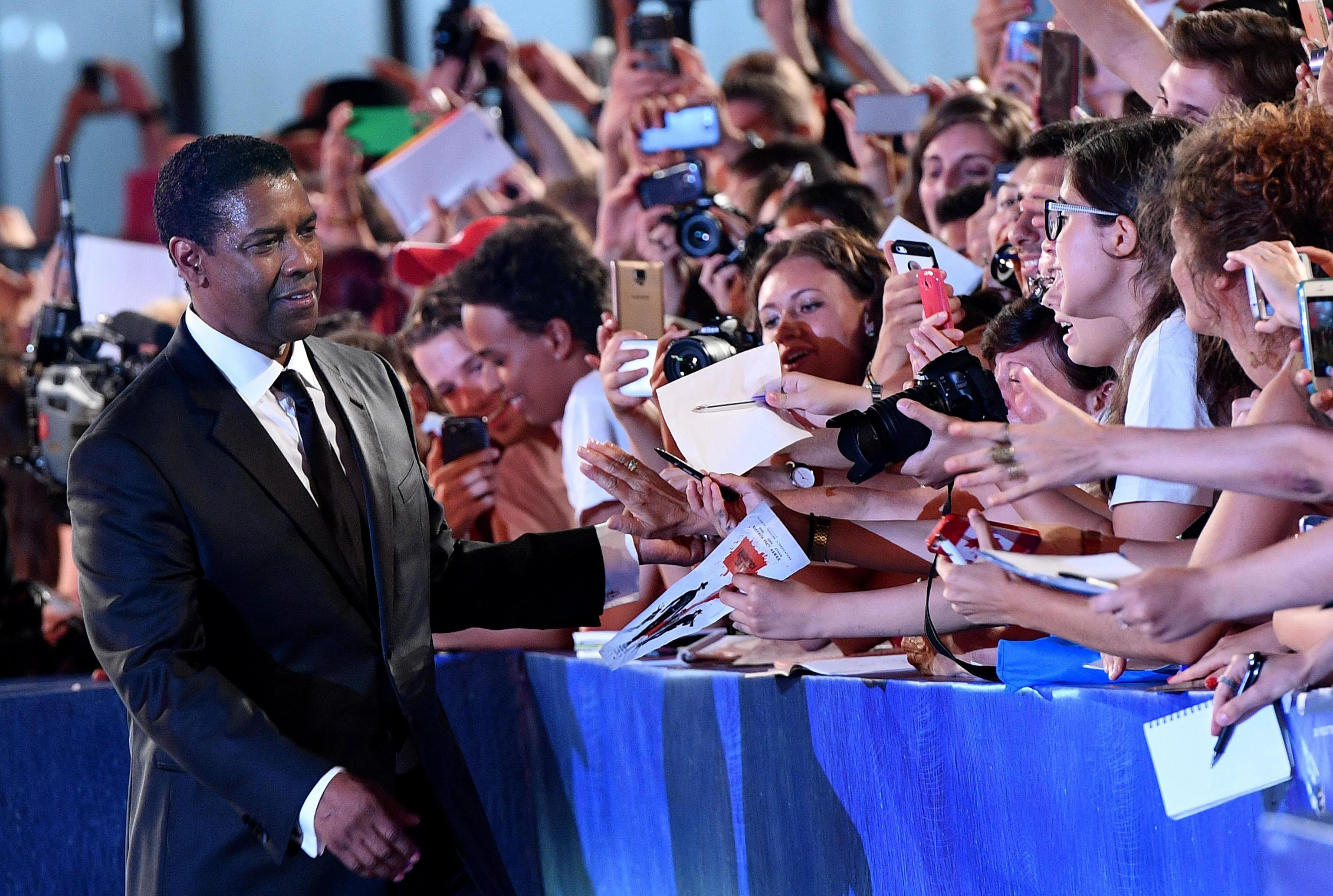 epa05534103 US actor Denzel Washington greets fans as he arrives for the screening of 'The magnificent Seven' during the 73rd Venice Film Festival in Venice, Italy, 10 September 2016. The festival runs from 31 August to 10 September. EPA/ETTORE FERRARI